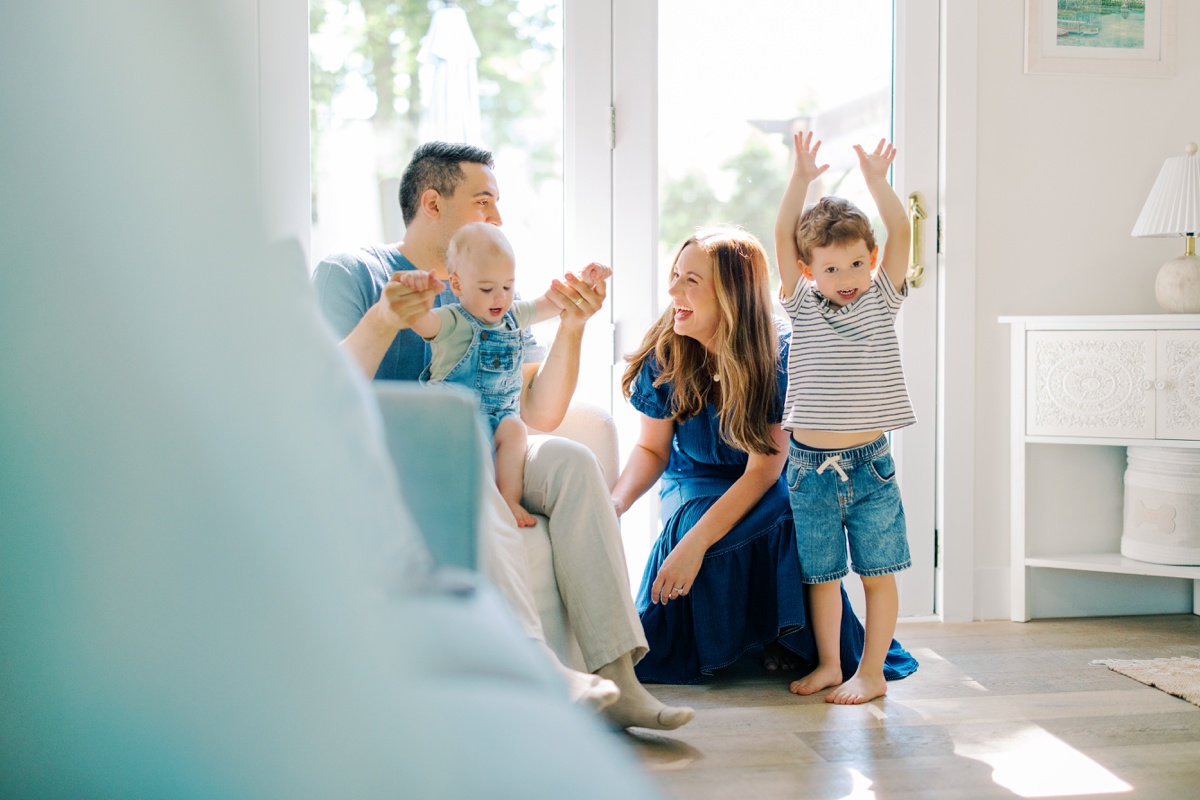Family dancing in the living room together as morning sunlight fills the room