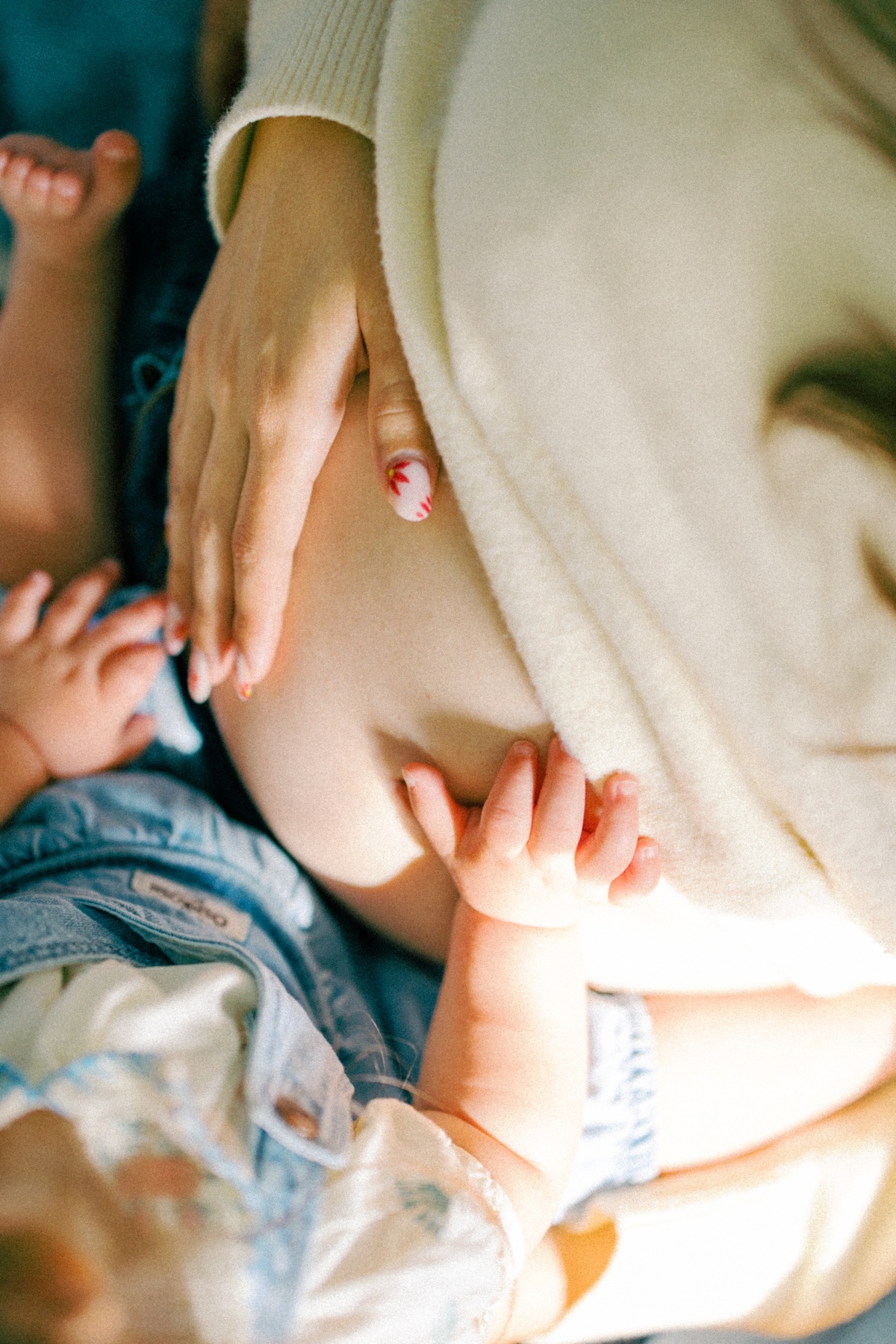 child placing hands on mothers growing belly