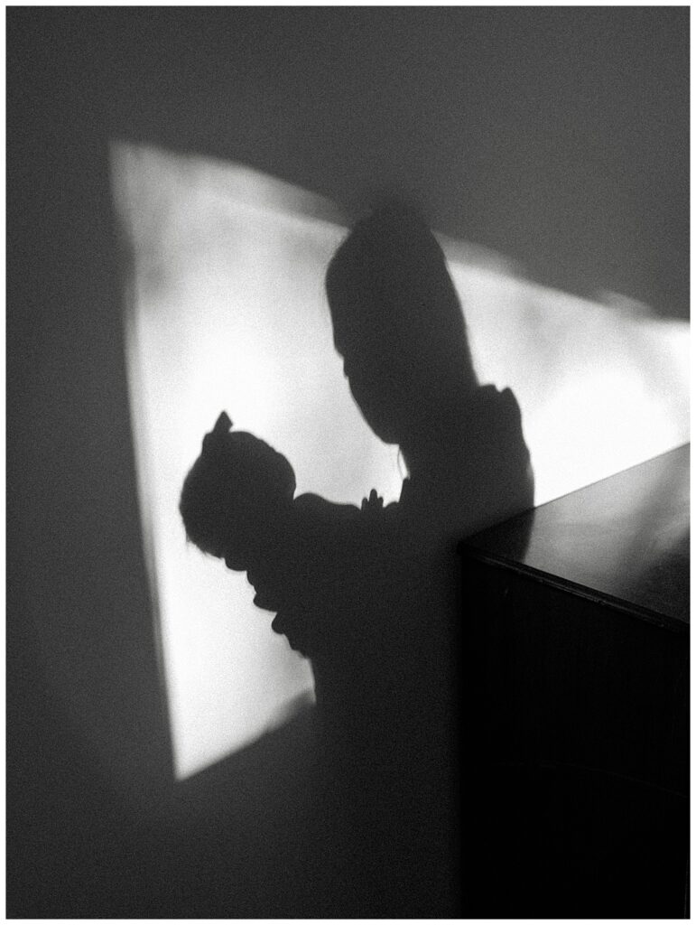 a silhouette shot of a mother and her baby girl in the living room