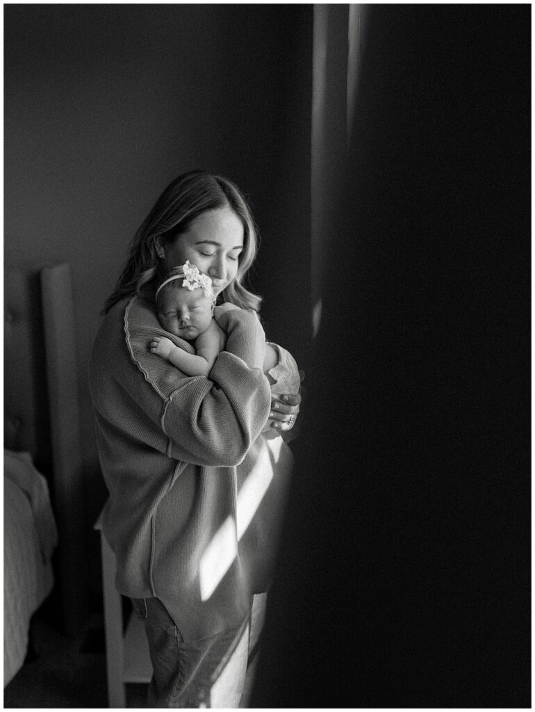mother holding baby girl while she soaks up the newborn phase